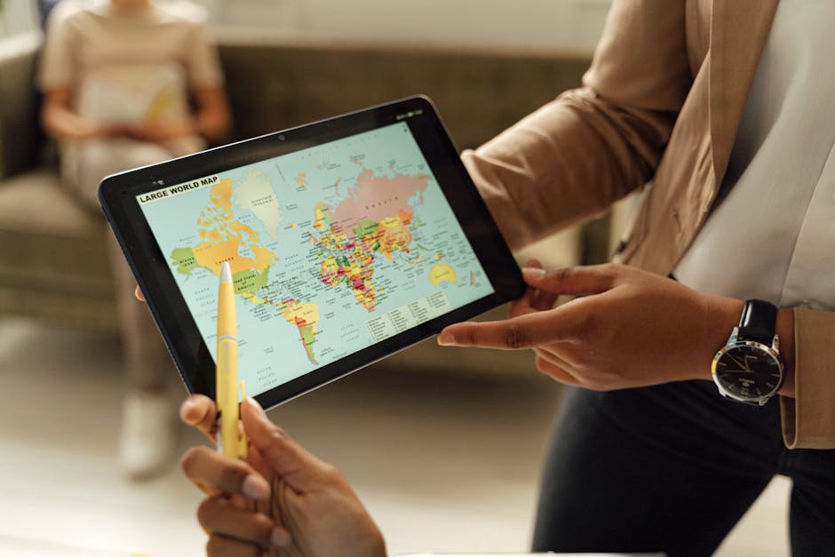 Close-up of hands holding a digital tablet displaying a world map, ideal for educational content.