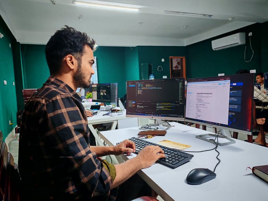Programer radi na dual monitor postavci u modernom uredu