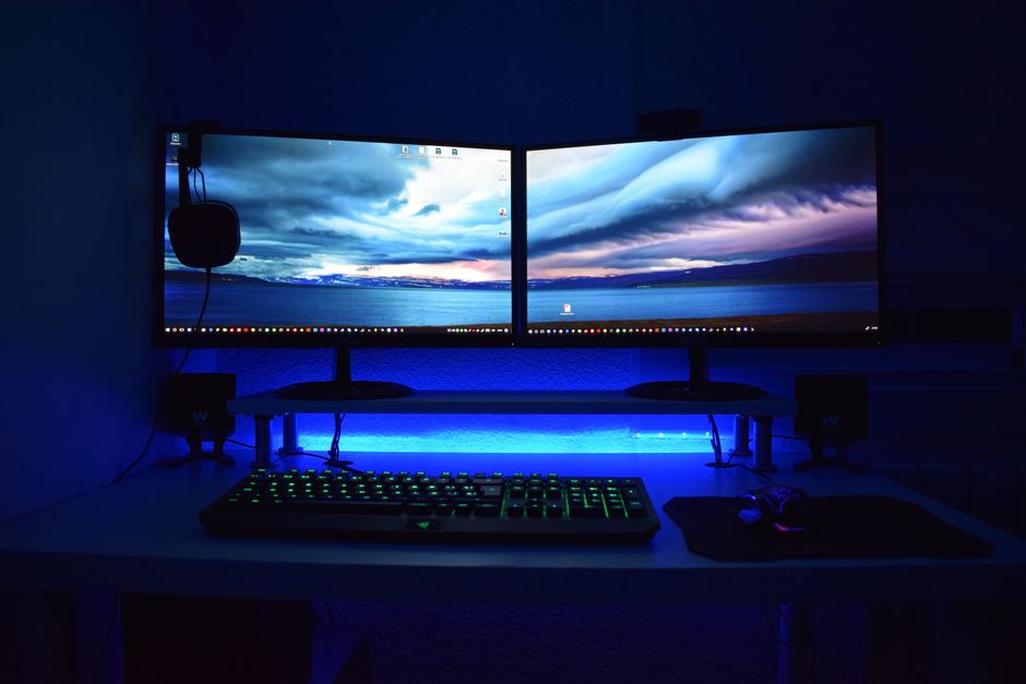 Dva monitora s plavim osvjetljenjem na gaming stolu